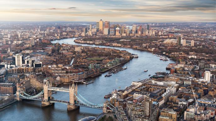 riel shot of London showing the River Thames, Tower Bridge and in the background Canary Wharf.